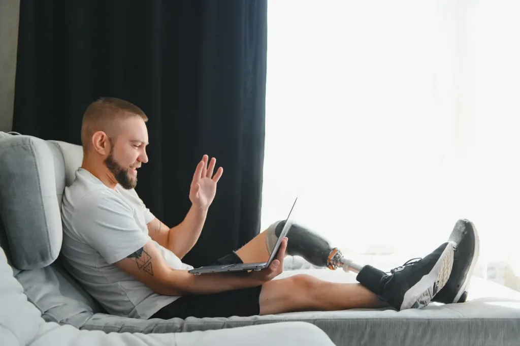 disabled man with a prosthetic leg looking at his laptop